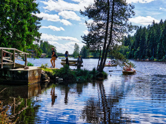 Menschen am See und in Runderbooten